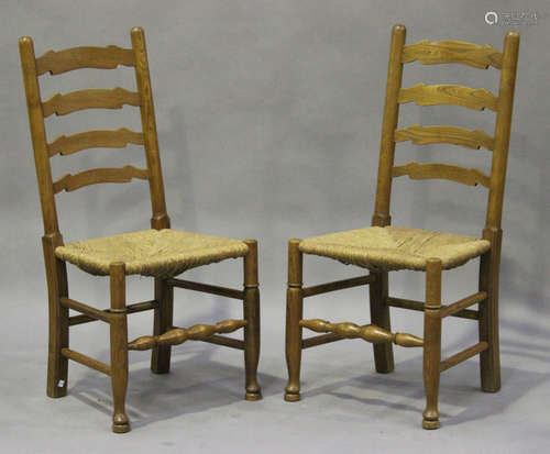 A set of ten late 20th century ash ladder back dining chairs, the rush seats raised on turned