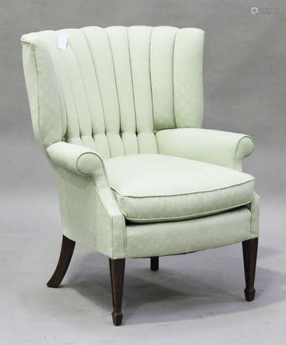 An Edwardian fan and wing back armchair, upholstered in green patterned fabric, on square tapering