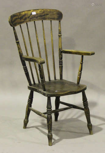 An early 20th century beech and elm Windsor armchair, the solid seat raised on turned legs united by