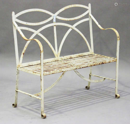 A 20th century Regency style white painted wrought iron garden bench with slatted seat, on scroll