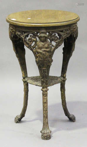 A 19th century cast iron pub table with later oak top, the base cast with masks and scrolls, on