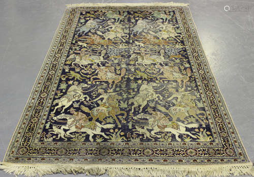 A Kerman pictorial prayer rug, mid-20th century, the ink blue field with an overall hunting scene,