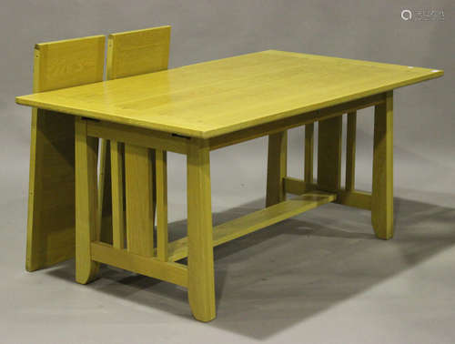 A modern Arts and Crafts style pale oak extending dining table with two extra leaves, raised on