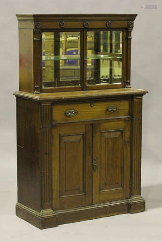 A Victorian mahogany side cabinet, the moulded pediment above a pair of glazed doors revealing a