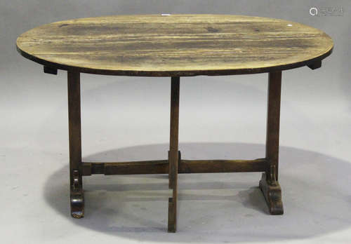 An 18th century French provincial walnut oval tip-top trestle table, on block supports and bracket