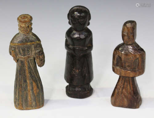 A group of three carved wooden figures, possibly early 17th century dolls, one carved in the form of