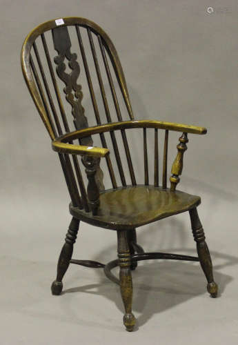 A 19th century yew and elm pierced splat back Windsor armchair, the solid seat raised on turned legs