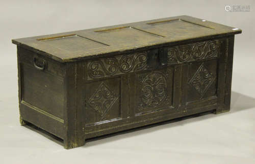 A late 17th century oak panelled coffer, the hinged lid revealing a candlebox, the triple panel