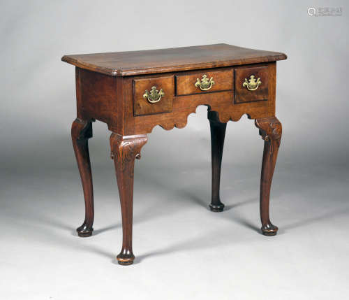 An 18th century and later walnut lowboy, the moulded top above three drawers and a shaped apron,
