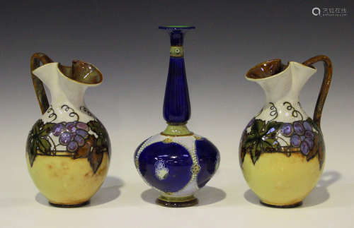 A pair of Royal Doulton stoneware jugs, circa 1922-56, each decorated with a fruiting vine border,