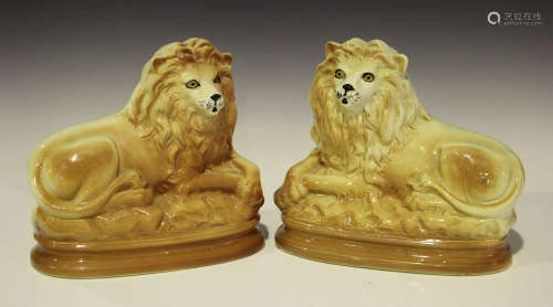 Two pairs of Staffordshire pottery lions, late 19th/early 20th century, inset with glass eyes, one