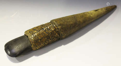 A Papua New Guinea polished stone adze, mounted onto a tapering wooden handle with woven rattan