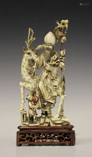 A Chinese carved and stained ivory figure group, early 20th century, modelled as Shoulao seated on a