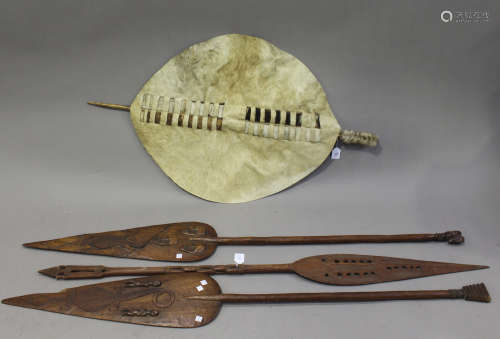 A group of three African hardwood paddle spears, carved in relief with snakes, crocodiles and