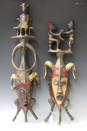 Two similar Senufo carved and painted wooden masks, Ivory Coast, both modelled with figural
