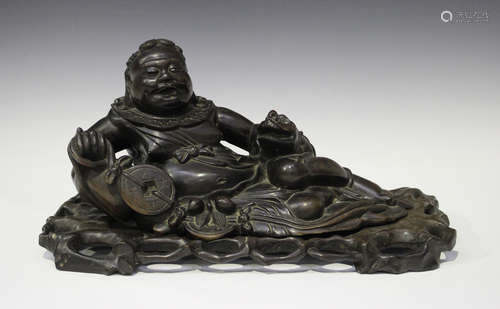 A Chinese carved hardwood figure of the immortal Liu Hai, early 20th century, modelled recumbent,