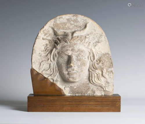 A Greek terracotta antefix, probably 4th century BC, the arched front decorated in high relief