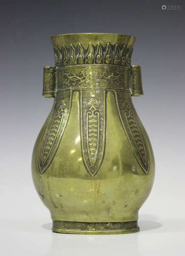 A Chinese archaistic polished bronze vase, late Qing dynasty, the flattened pear shaped body cast