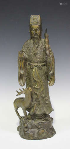 A Chinese cast bronze figure of an immortal, 20th century, modelled standing and accompanied by a