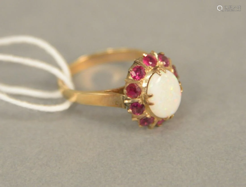 14K gold ring set with oval opal surrounded by red