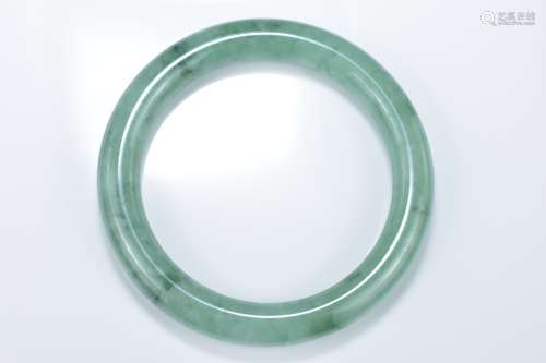 A Chinese pale and green jadeite bangle. 6cm inner diameter