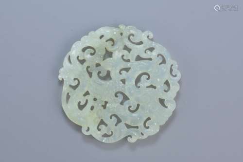 A Chinese carved jade pendant depicting a dragon and phoenix. 6cm diameter