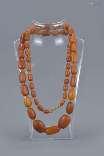 A graduated amber bead necklace. Bead size 9mm - 24mm length. Weight total 64 grams