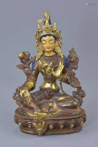 A Tibetan partial gilt bronze Buddha with painted face seated on lotus base. 20.5cm tall