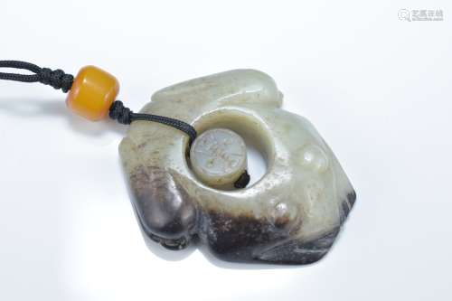 A Chinese celadon and brown jade frog with separate central jade piece with 'Shou' character wishing
