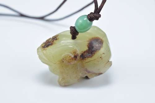 A Chinese carved celadon and brown jade animal pendant. 3.5cm length