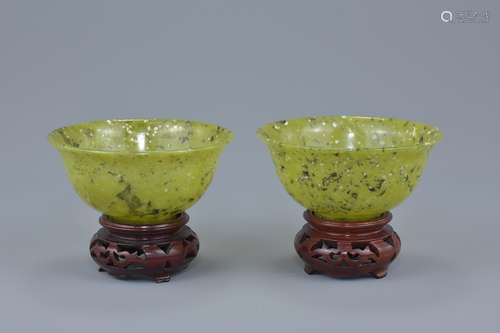 A pair of Chinese bowenite bowls with wooden stands. 10cm diameter (4)