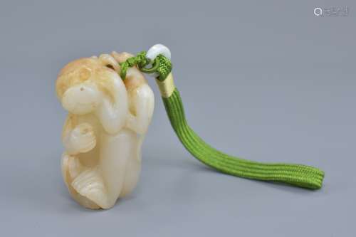A Chinese pale celadon and brown jade pendant carved as a monkey with baby. 7cm height