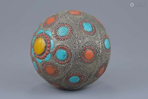 A large Tibetan decorative ball with hammered white metal, turquoise, coral and amber coloured stone