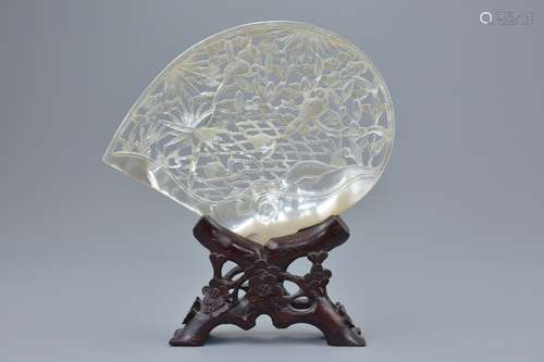 A Chinese vintage mother-of-pearl shell with pierced decoration depicting birds in tree on wooden st