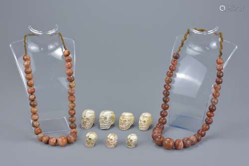 Two graduated agate beaded necklaces together with seven resin modeled skull beads. Skulls 2cm-3.5cm