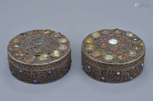 A pair of Nepalese / Tibetan white metal filigree boxes and covers decorated with coloured stone ins