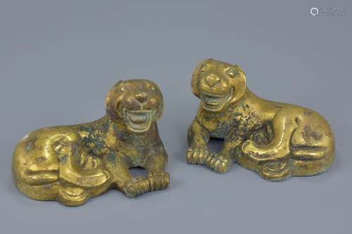 A pair of Chinese gilt bronze figures of resting lions. 18cm length. 1696 grams and 1646 grams (2)