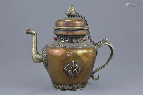 A large Tibetan copper and white metal ewer with cover. Decorated with coloured stones. 29cm tall