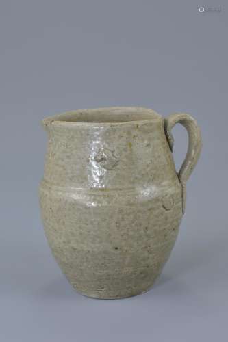 A Chinese Western Jin dynasty (265-316AD) celadon pottery jug with single looped handle. 10cm tall