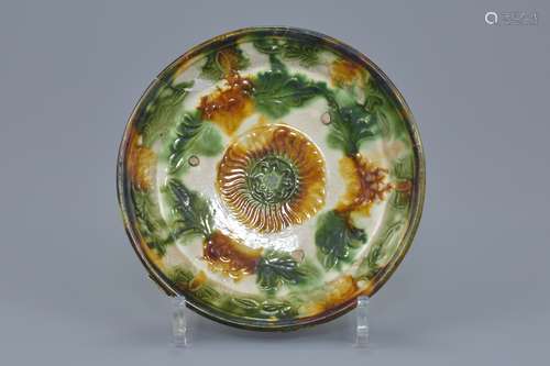 A Chinese Tang dynasty Sancai glazed shallow dish with molded floral decoration. 17cm diameter