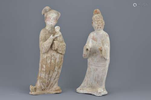 Two Chinese Tang dynasty white pottery painted figures of a man and lady holding a baby. Figure of t