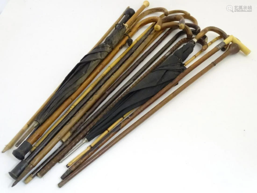 A collection of sticks, canes and umbrellas, variously