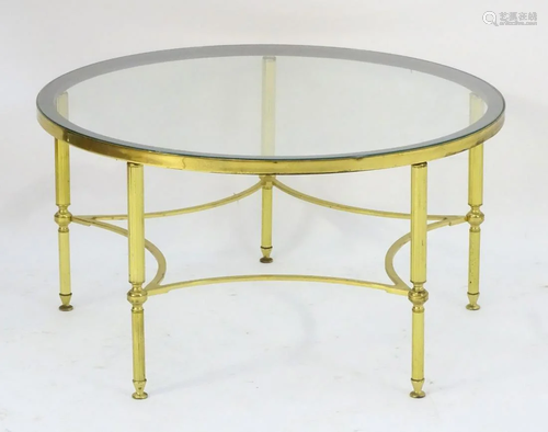 A mid 20thC glass top table with a brass base and …