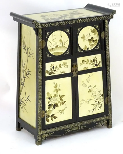 A 20thC oriental cabinet with panelled doors …