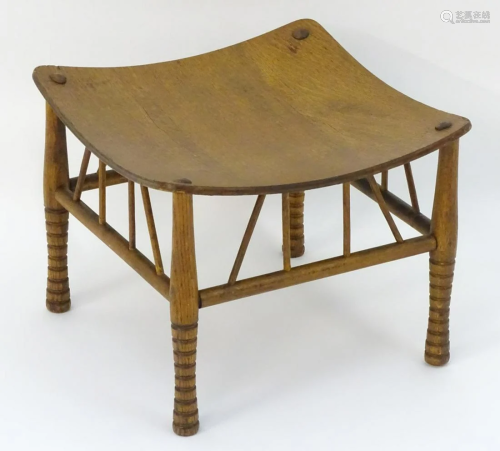An early 20thC oak Liberty style Thebes stool with a
