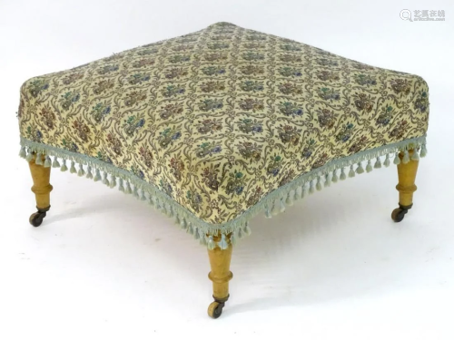 An early 20thC footstool with an upholstered sprung top
