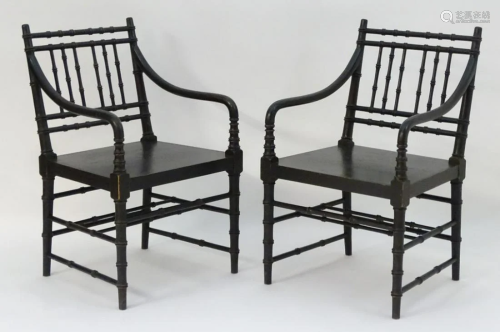A pair of ebonised open armchairs in the manne…