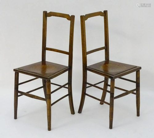 An pair of early 20thC beech chairs with shaped top