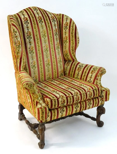 An early 20thC wingback armchair standing …