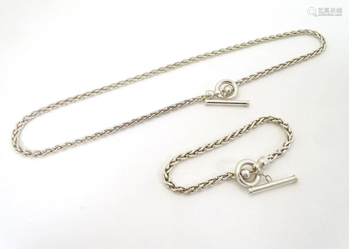 A silver necklace of rope twist form with matching